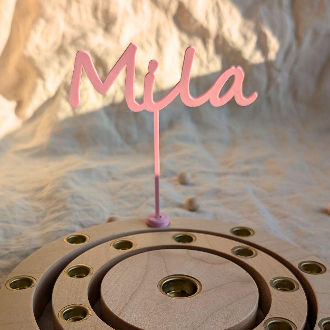 Personalisierter Namensstecker mit Namen Mila in rosa, mit Adapter befestigt im Geburtstagsring