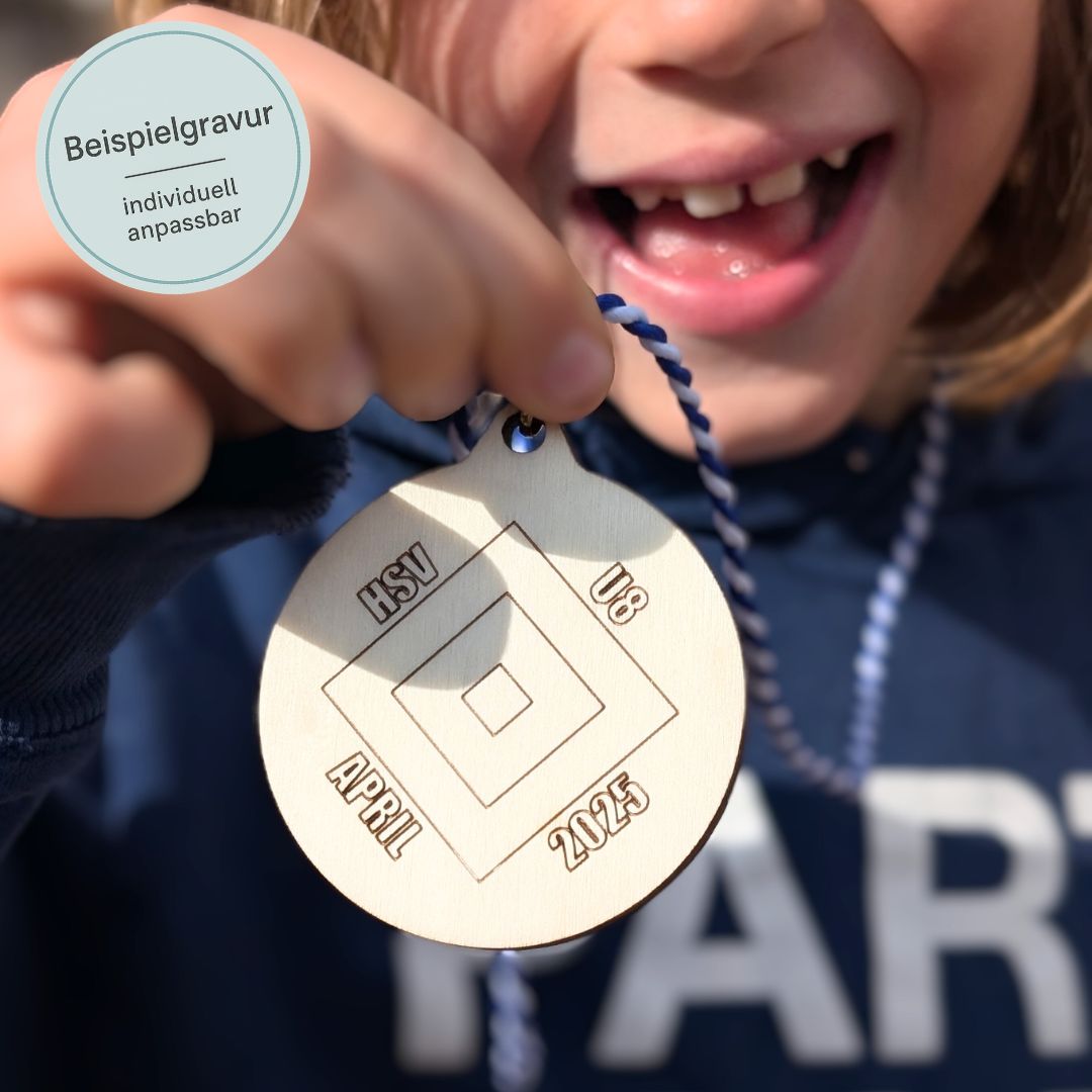 Lachendes Kind hält Medaille aus Holz in die Kamera.