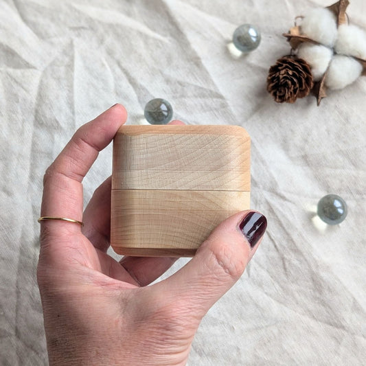 Kleine Tamponbox aus hellem Ahornholz, geschlossen, in einer Hand gehalten – handgefertigt und handlich