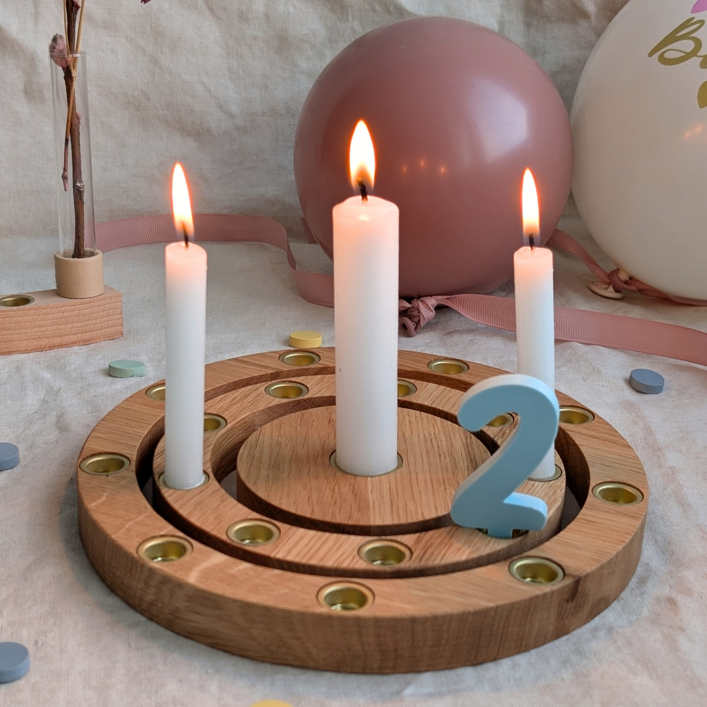 Geburtstagsring aus Eiche mit brennenden weißen Kerzen und graublauem Zahlenstecker