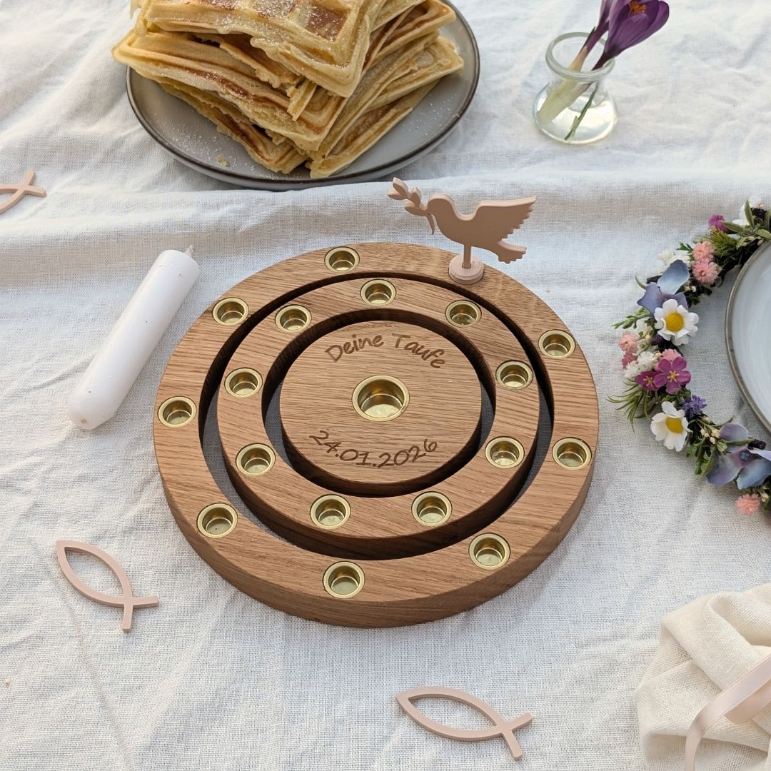 Motivstecker im Ring zur Taufe auf gedecktem Tisch mit Kerzen und Blumen
