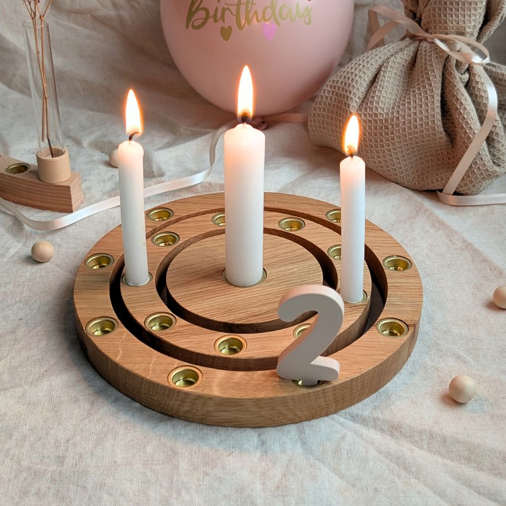 Geburtsagstisch mit Geburtstagsring und angezündeten Kerzen sowie Zahlenstecker.