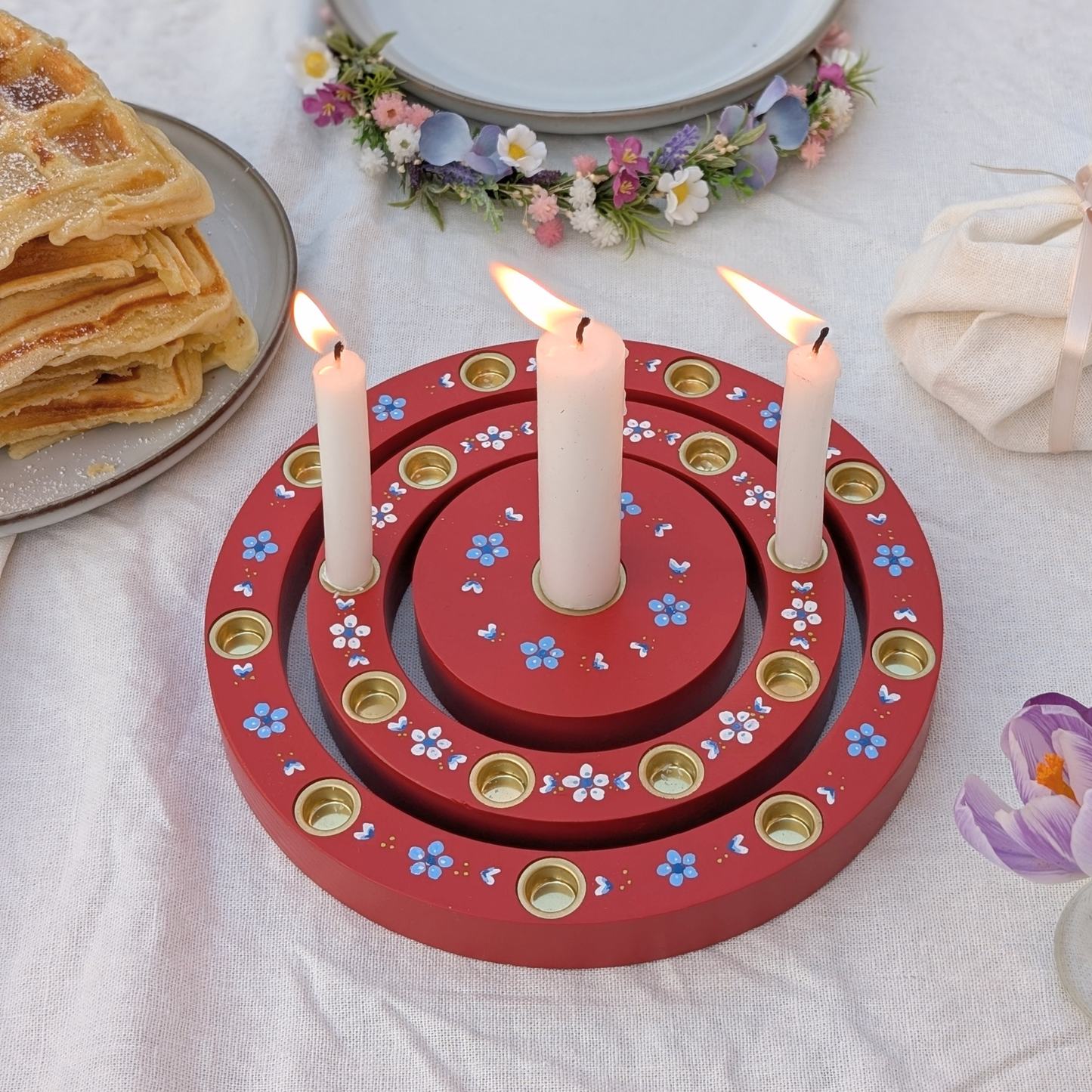 Geburtstagstisch mit rotem Geburtstagsring, brennenden Kerzen und Geburtstagskuchen