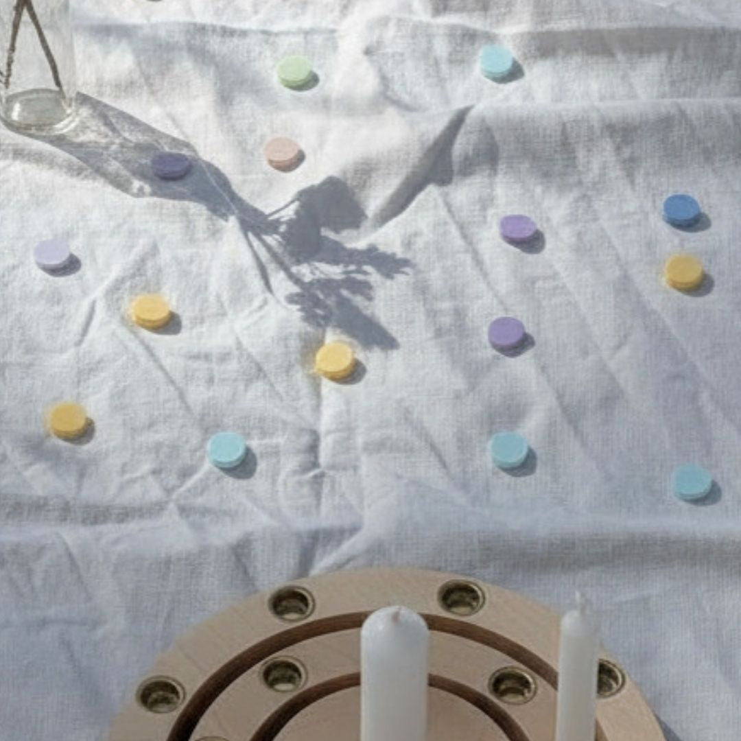Pastellfarbenes Streukonfetti aus PLA auf Leinentisch mit Holz Geburtstagsring – nachhaltige Tischdeko Kindergeburtstag