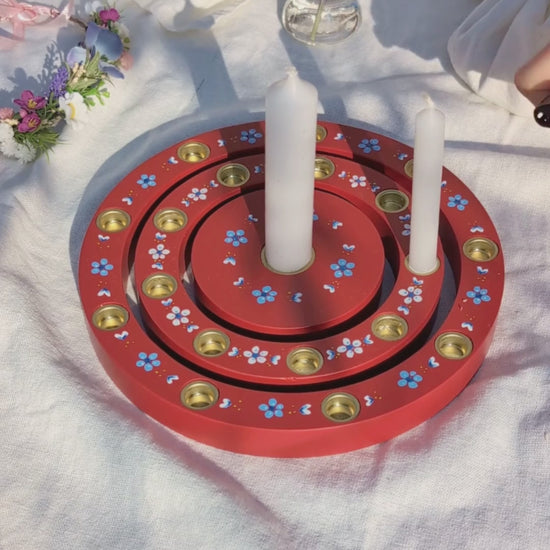 Geburtstagsring aus Holz mit Kerzen auf Tisch im Garten zwischen Blumen