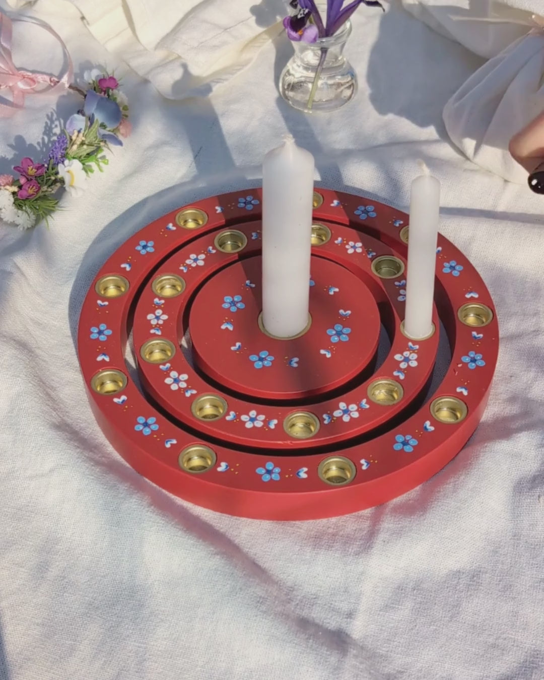 Geburtstagsring aus Holz mit Kerzen auf Tisch im Garten zwischen Blumen